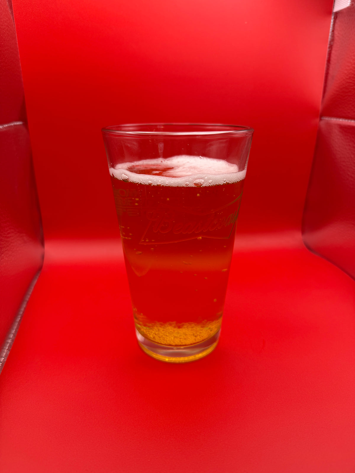 BeastCoast Americana Pint glass with beer on red background, side view